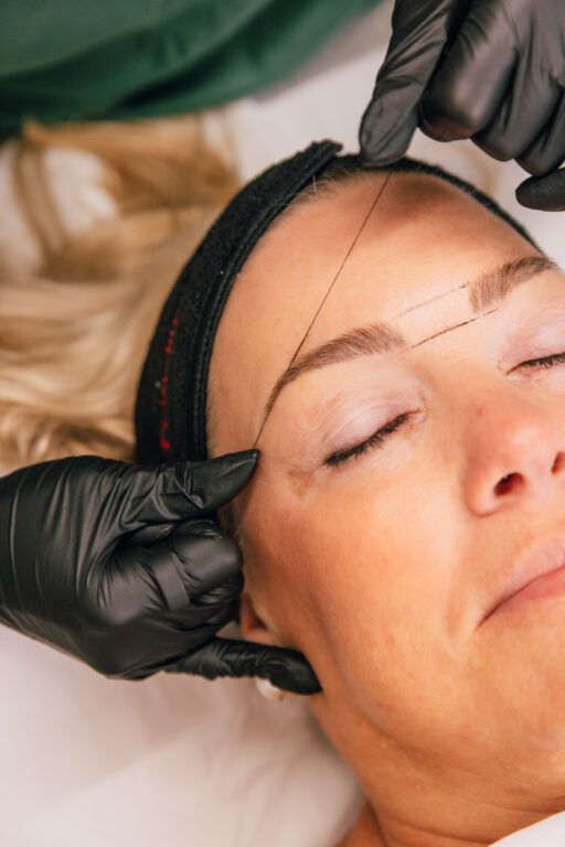 Client receiving a professional brow lamination treatment at The Pip Rx in Overland Park as the brow hairs are shaped and lifted into place.
