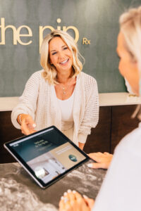 Client at The Pip Rx wellness clinic in Overland Park learning about GHK-Cu glow peptide therapy for skin and healthy aging.